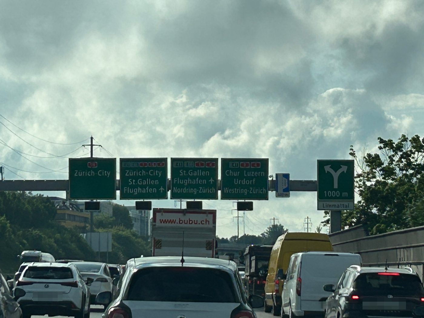 Stau auf der Autobahn A1 vor der Verzweigung Limmattal, Wegweiser Richtung Zürich-City, St. Gallen und Chur.
